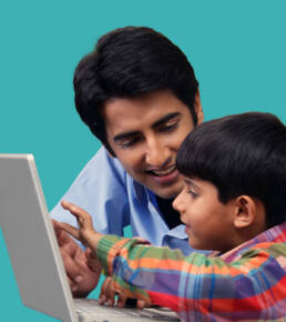 Father and son using a touchscreen laptop