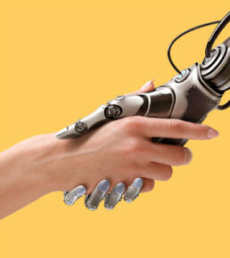 Machine hand shaking human hand